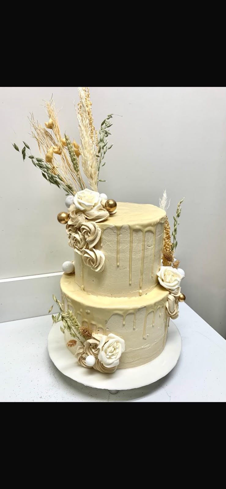 Elegante zweistöckige Festtagstorte in Creme und Gold