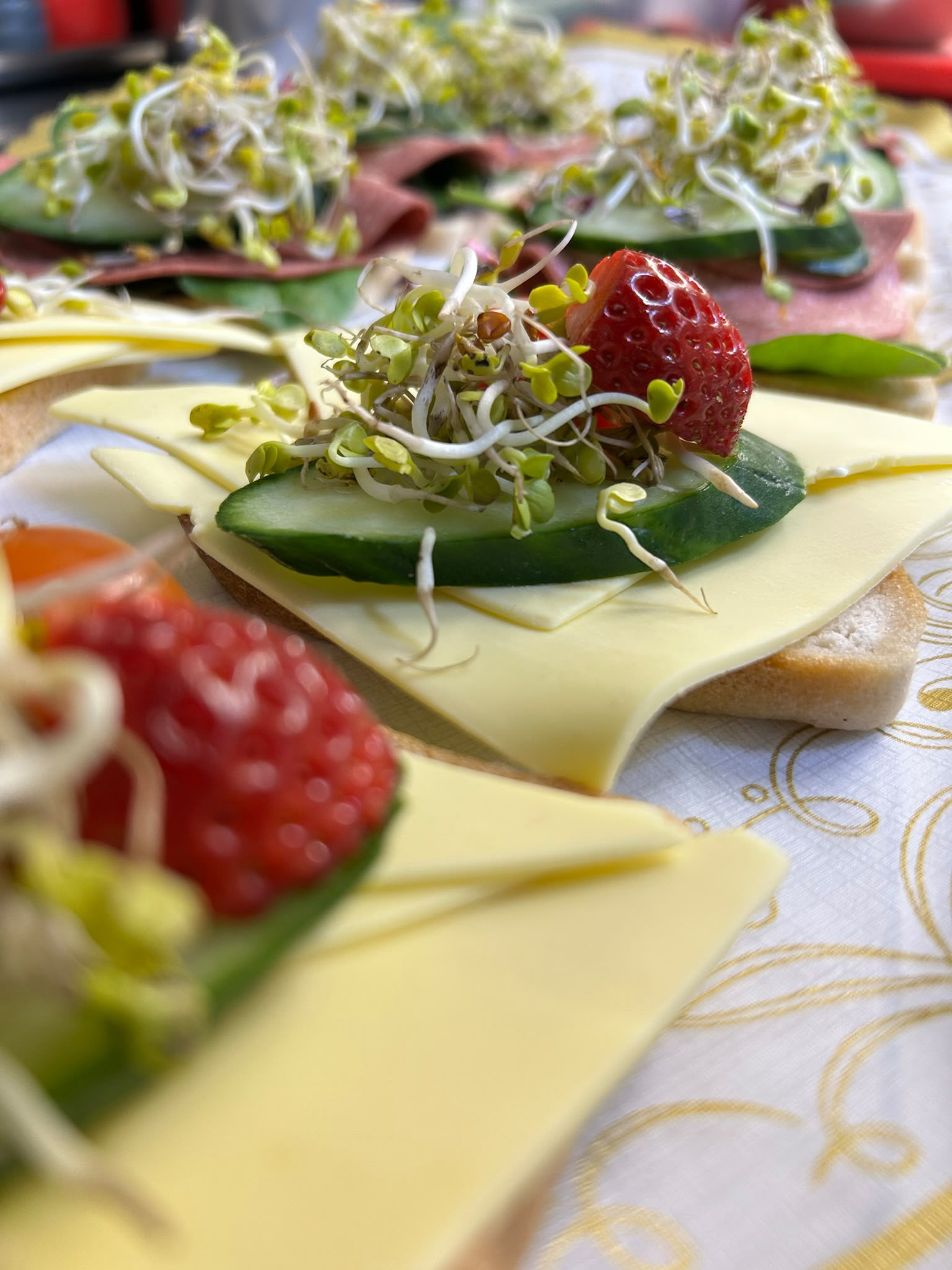 Käsehäppchen mit Gurke, Sprossen und Erdbeeren