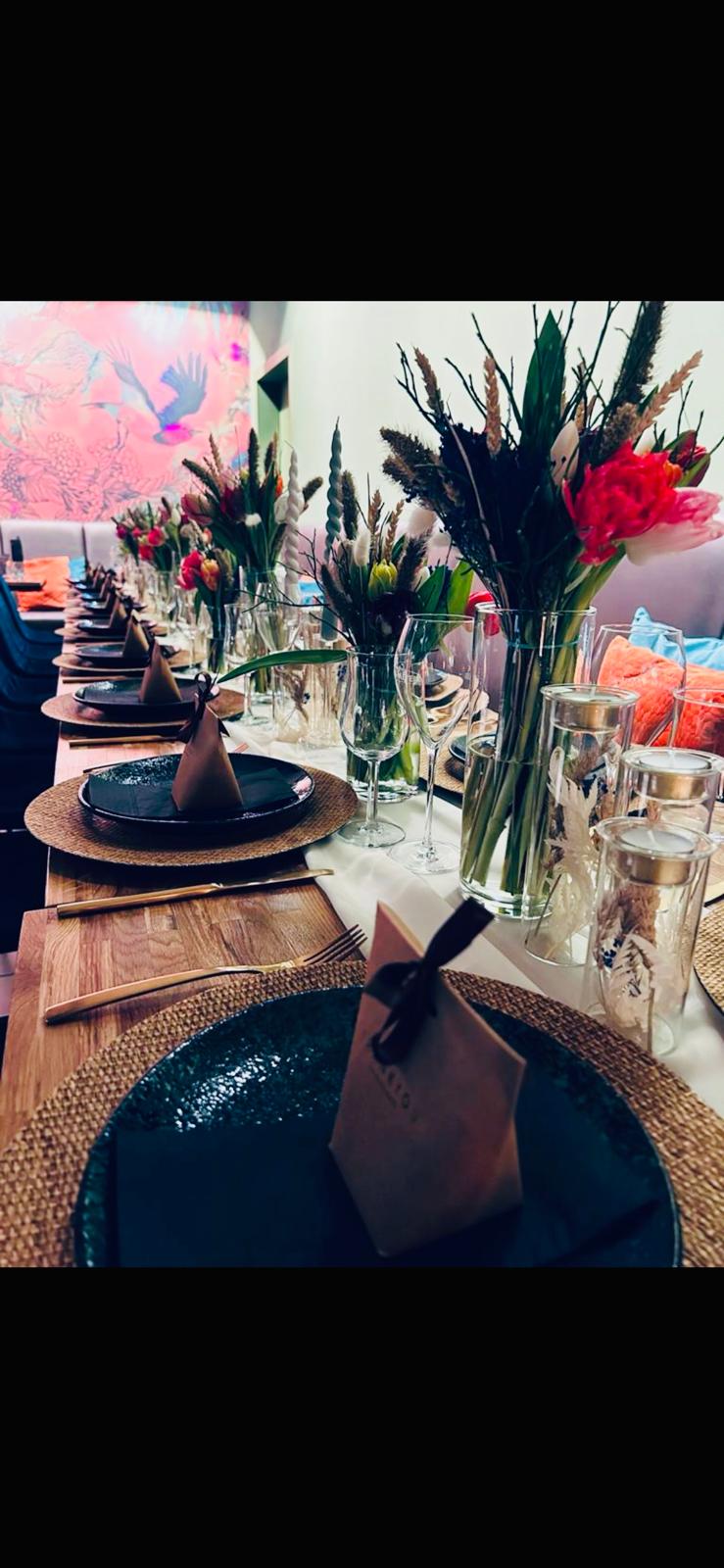 Festlich gedeckte lange Tafel mit frischen Blumen im Café Maute